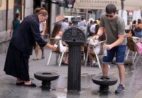 Både Spania og Frankrike opplever unormalt høye temperaturer. Her drikker folk i Madrid fra en fontene. 